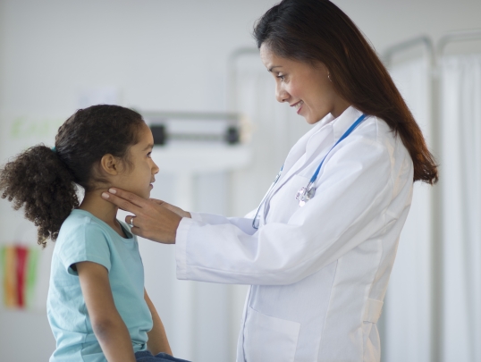 A photograph of a doctor with a pediatric patient