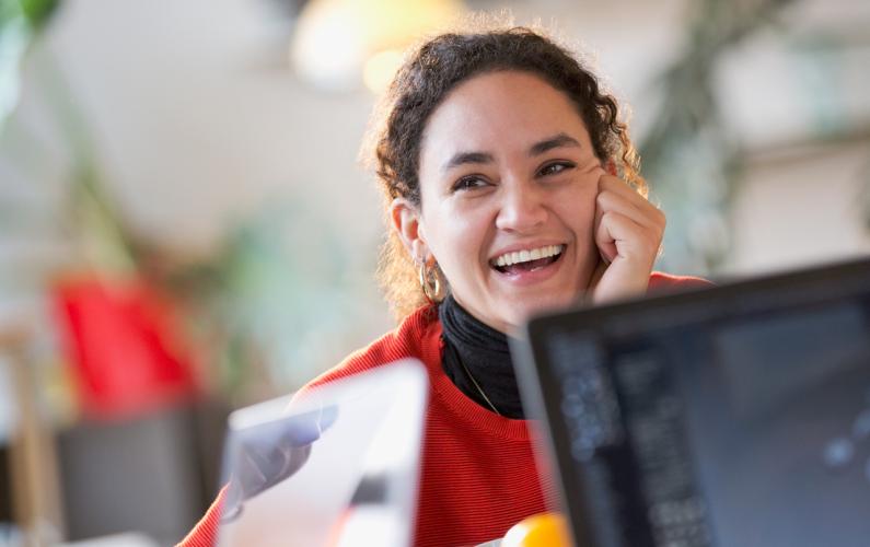 Woman smiling by laptops