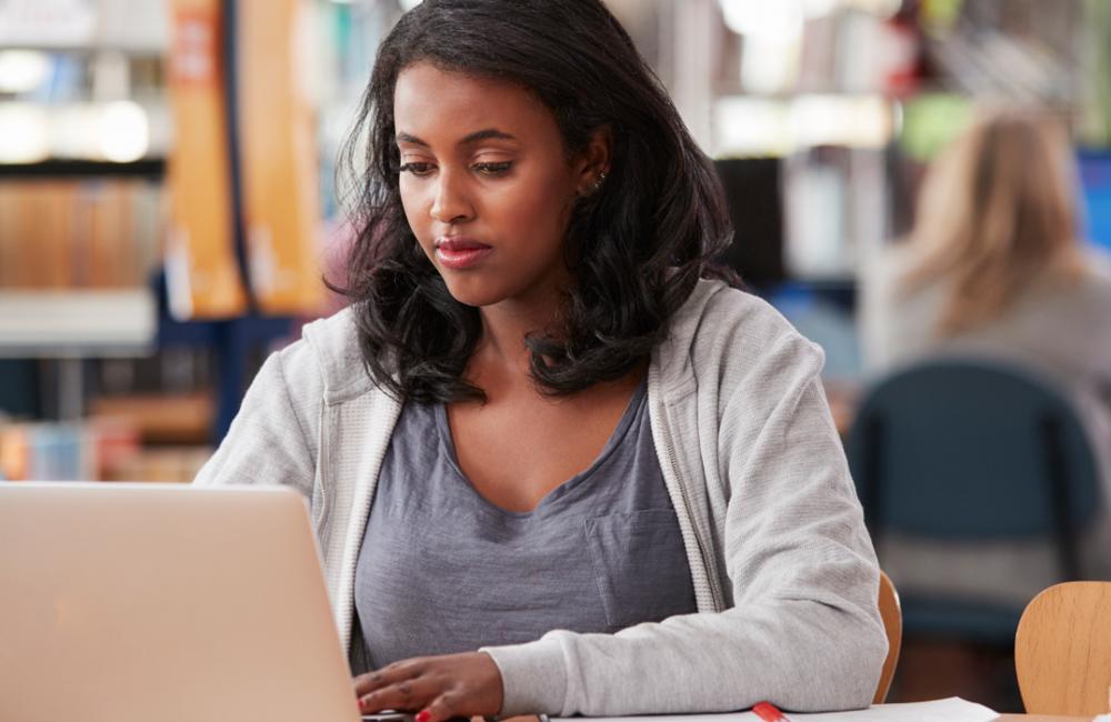 female student on laptop in library