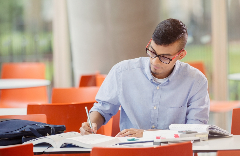 student sitting at table taking notes